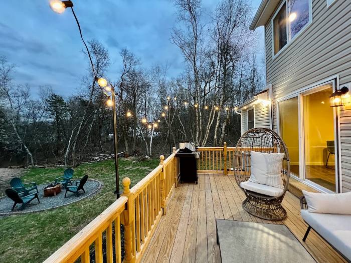 Deck with string lights and the fire pit beyond